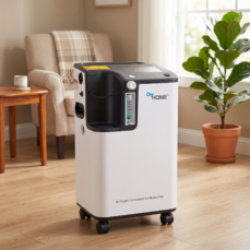 OxyHome 5L stationary oxygen concentrator in a warm home living room next to an armchair, ready for daily home oxygen therapy