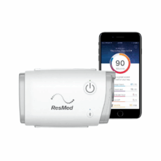 AirMini AutoSet travel CPAP beside a smartphone running the AirMini app