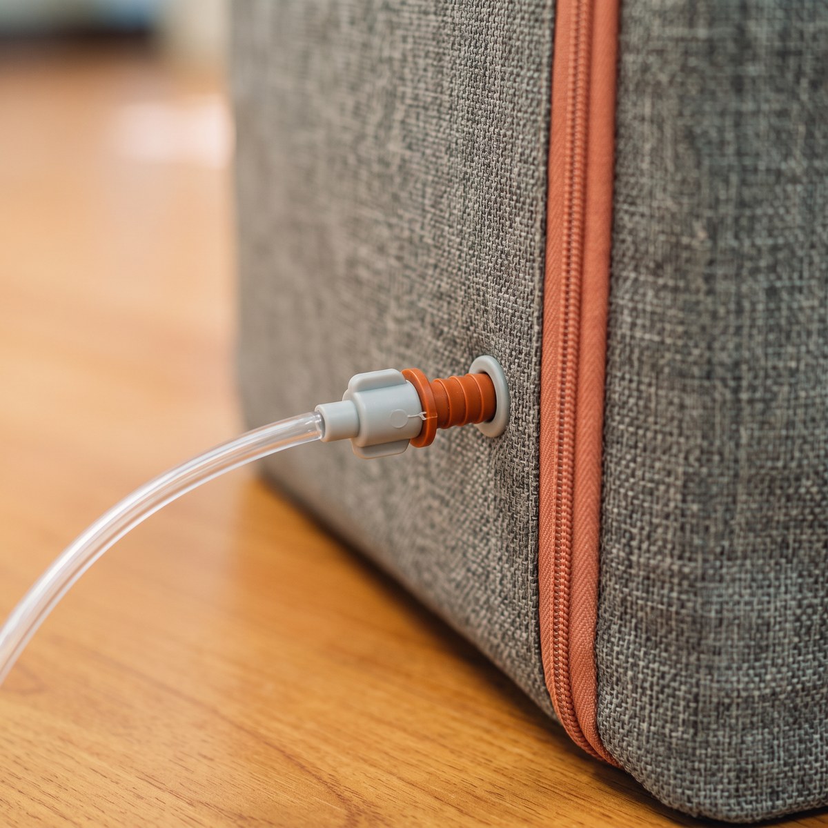 Close-up of the oxygen tubing connector plugging into the port of a pet oxygen chamber — simple setup for oxygen therapy for dogs and cats