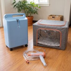 Complete pet oxygen rental kit at home: oxygen chamber, oxygen concentrator and tubing on a living room floor — Miami same-day delivery