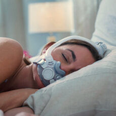 Mujer durmiendo de costado con la máscara facial completa AirTouch F30i Clear