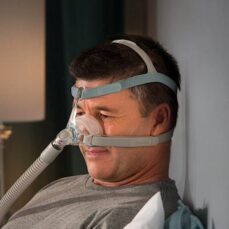 Hombre en la cama con la máscara nasal CPAP F&P Eson 2 puesta