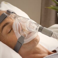 Hombre durmiendo con la máscara CPAP facial completa Simplus de Fisher & Paykel